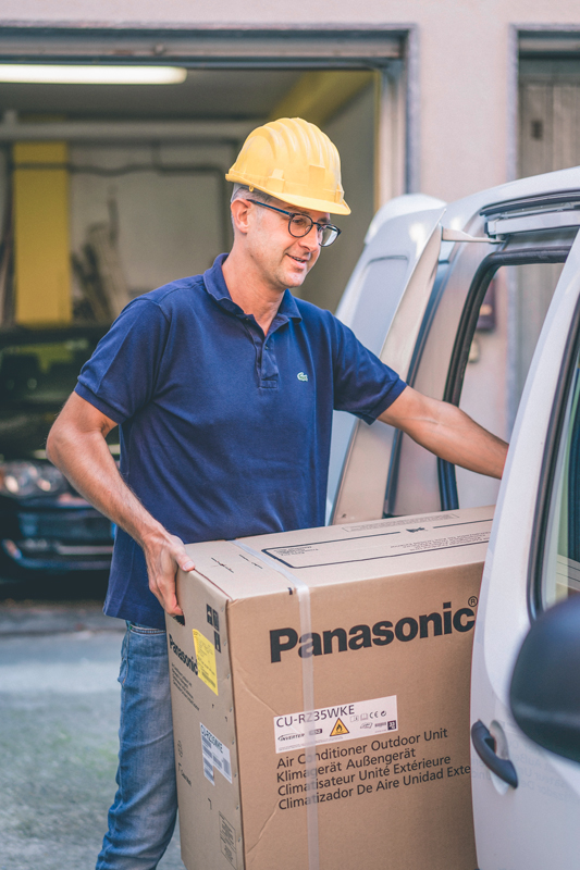 Loading the van with a Panasonic HVAC outdoor unit.