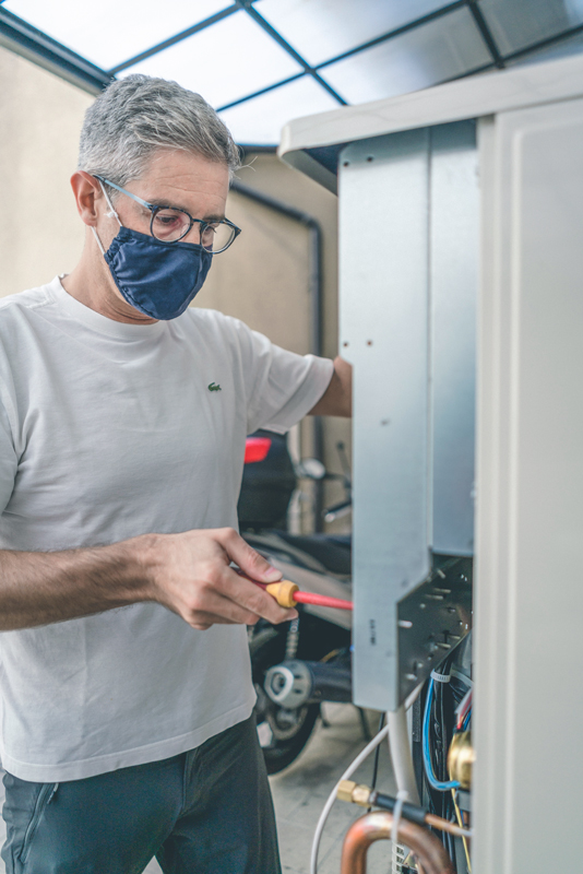 Alessandro, is manipulating the electrical components of an HVAC outdoor unit.