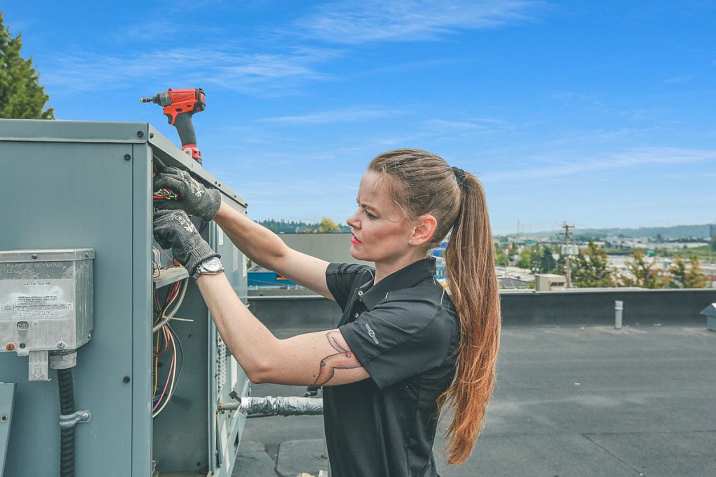 Jessica is hand-on on the HVAC roof unit.