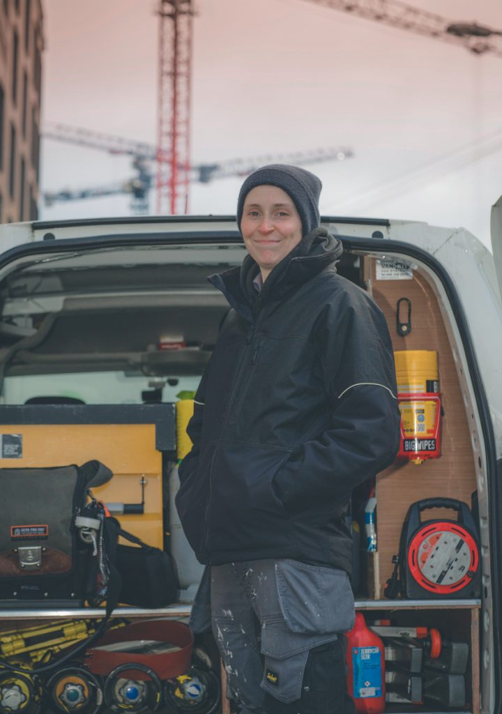 Ruth Gill in the back of her vehicle with air conditioning maintenance equipment.