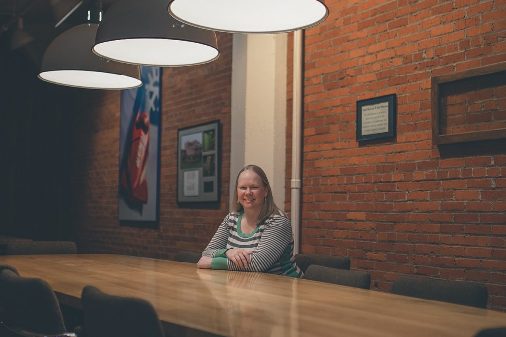 Picture of Lauren sitting in the middle of a long empty table.