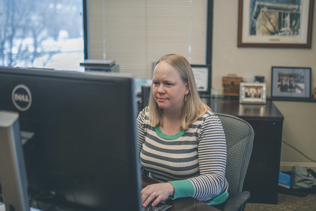 Picture of Laure. She is typing on her computer keyboard.